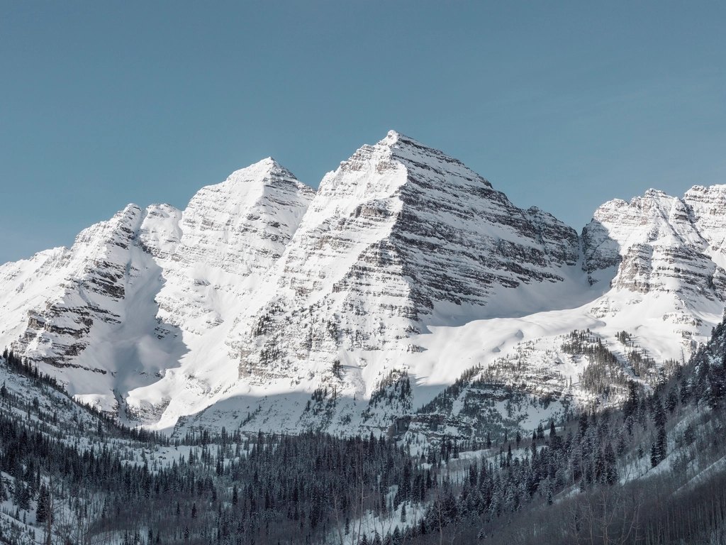 The snow-covered Maroon Bells against a clear Colorado sky